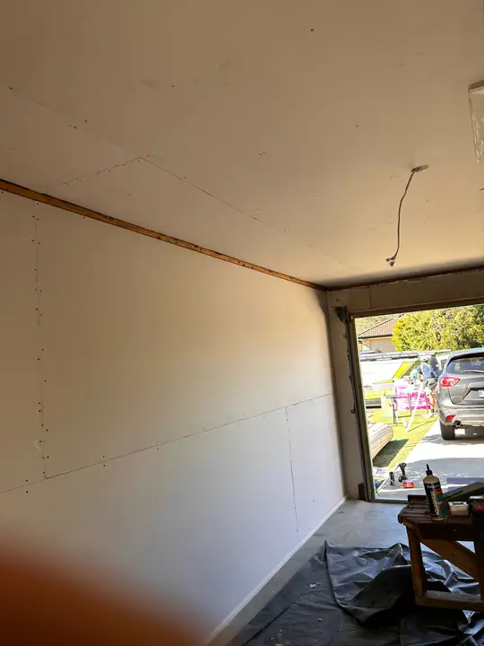 Garage walls and ceiling made safe after hazardous sheeting removal.