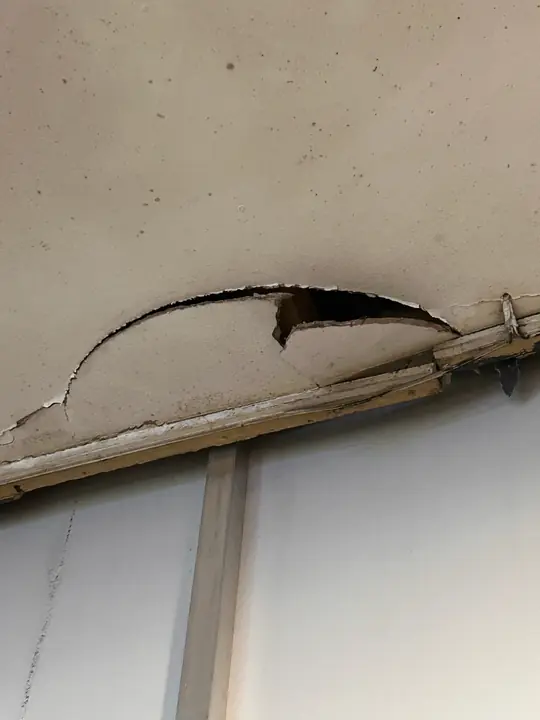 Collapsing water-damaged ceiling, isolated and treated as hazardous until tested.
