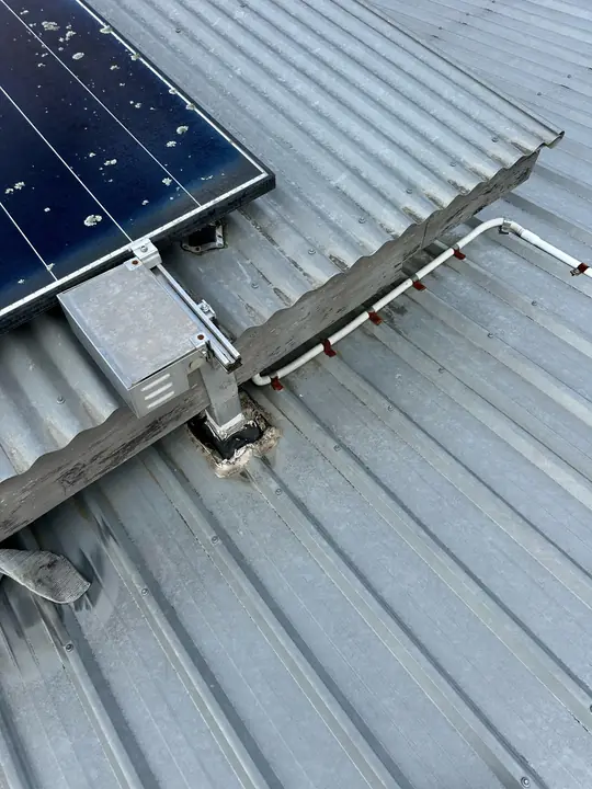 Solar mount penetration on a metal roof, identified as the leak point.